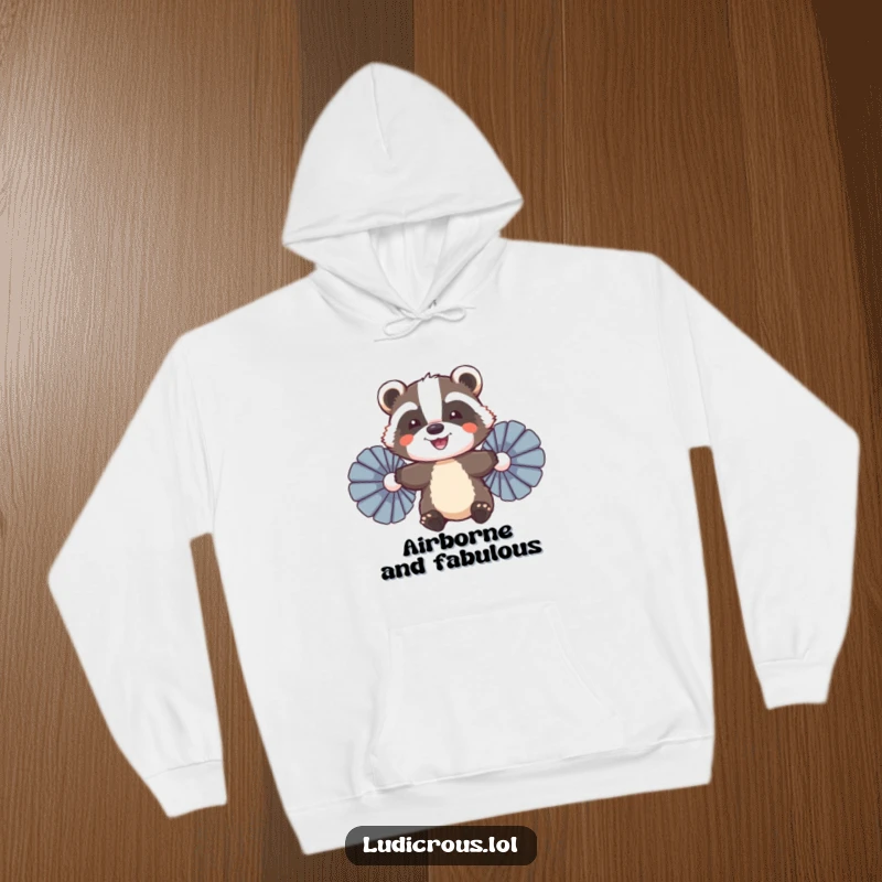 Funny Badger Hoodie, a smiling badger attempting to fly with large feather fans, looking determined and cheerful.