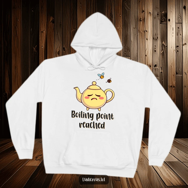 Funny nervous teapot hoodie, depicted whistling steam aggressively at a fly, offering warm comfort and humor.