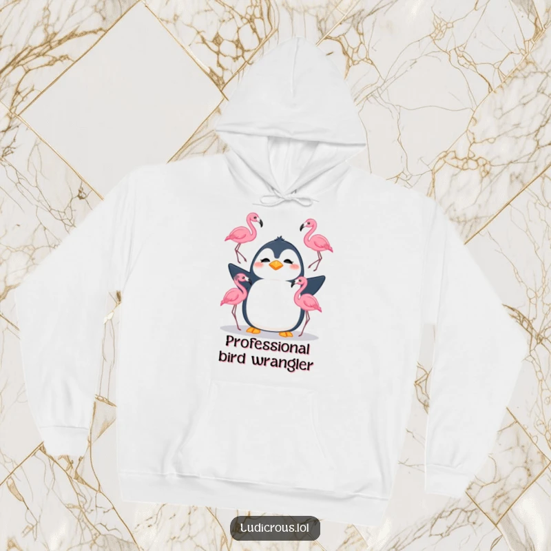 Funny hoodie showing a silly penguin with a confused expression juggling three flamingos, offering warm and humorous apparel.
